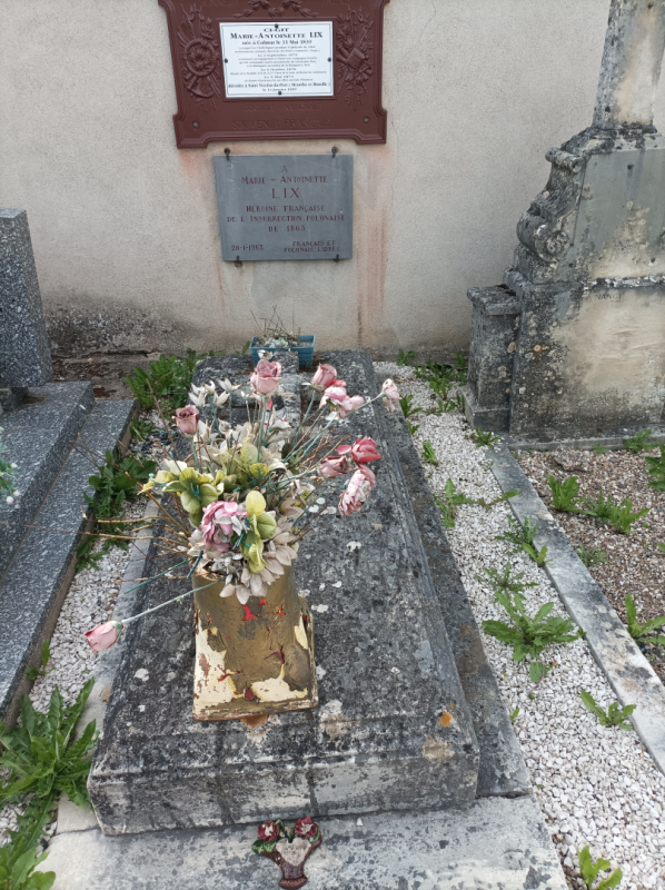 Kamienny stary zniszczony nagrobek Marie-Antoinette Lix z wazonem kolorowych kwiatów